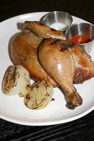 CLUCK IT UP: A whole organic chicken is brined in black tea, salted, and cooked in a wood-fire rotisserie until it is bursting with juices. A half chicken is more than enough to share and comes with house-made hot sauce and buttermilk dip. - PHOTO BY HAYLEY THOMAS