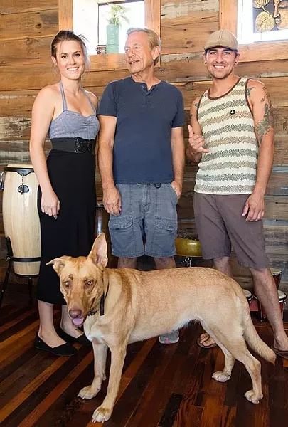 BEHIND THE BEER: From left, Bang the Drum Director of Marketing Noelle DuBois, father and Bang the Drum Brewery President Gary DuBois, and Head Brewer Jeremy Edward Fleming on deck at the new beer hangout located on Orcutt Road in SLO. Brewery dog Lyra is wondering where her pint is. - PHOTO BY TOM FALCONER
