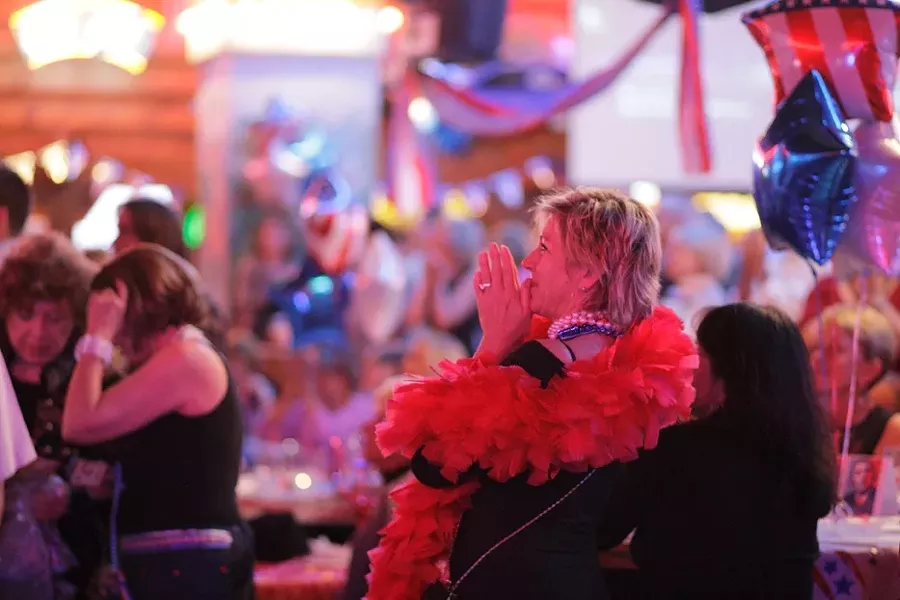 INAUGURAL BALL : Cynthia Hostetter celebrates a moment shown on the big screen at the ball. - PHOTO BY STEVE E. MILLER