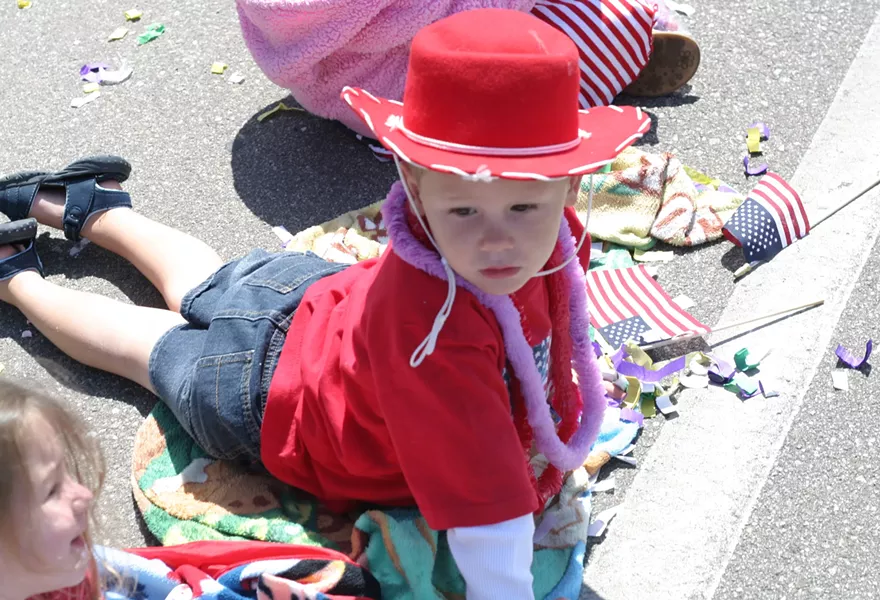 WONDER YEARS : A cowboy-hatted tyke gazes in amazement as the parade rolls past. - PHOTO BY GLEN STARKEY
