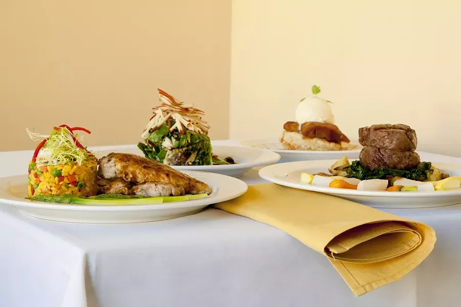 CROSS COUNTRIES : What do you get when you mix Cuban and Italian cuisine? How about (left to right) arroz con pollo a la Cubana, compressed Manchego salad, apple tart, and filet mignon? - PHOTO BY STEVE E. MILLER