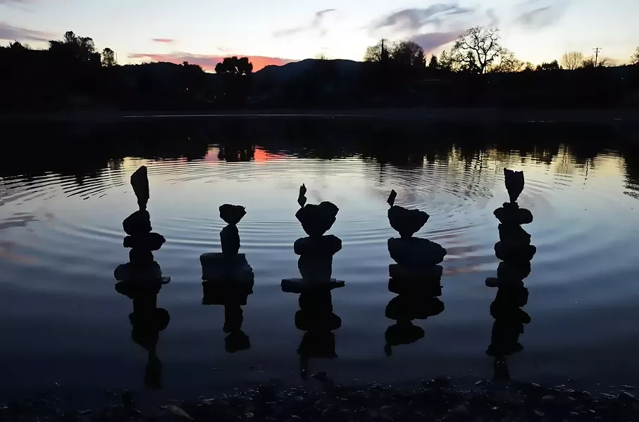 TOP OF THE LAKE: Clarke often sets and photographs her rock balances in a scenic location, like that of Atascadero Lake (seen above). - PHOTO COURTESY OF KATHY CLARKE