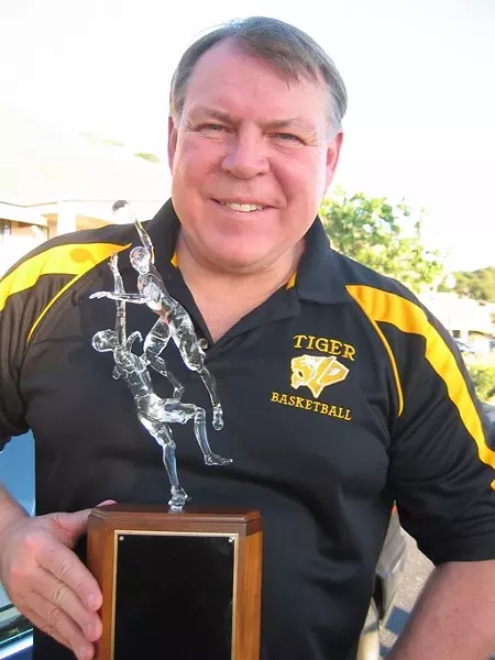 PROUD HOOPS COACH : Warren Hooper of Hooper Studios recently sculpted the trophy at the center of San Luis Obispo and Mission College Prep high schools’ basketball rivalry. SLO High assistant basketball coach Kirby Gordon (pictured with the trophy) called it “exquisite.” - PHOTO COURTESY OF KIRBY GORDON