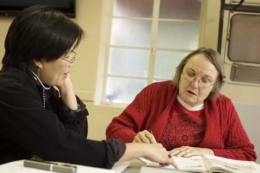 HELPING HAND : Thai native and ESL student Usa Koonvirarak (left) gets one-on-one tutoring from Marty Nelson. - PHOTO BY STEVE E. MILLER