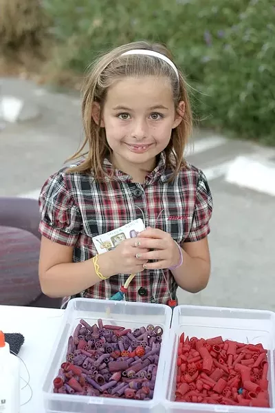 MACARONI NECKLACE QUEEN : Sevryn Jiminez, 9, crafts a necklace at one of the craft stations set up during the Salon 544 silent auction. - PHOTO BY GLEN STARKEY