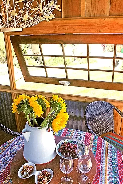 NEW USE: The Clarkes’ shed includes windows and a French door the couple collected, as well as reclaimed wood and aluminum tracked down by A Place to Grow owner Dana O’Brien. - PHOTO BY JOE PAYNE