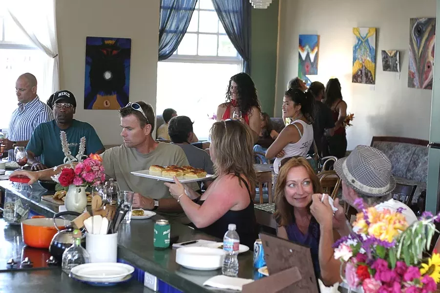 FACES IN THE CROWD : About 40 or 50 people gathered throughout the afternoon for Linda Castellon’s art opening at Sustenance Cooking Studio. - PHOTO BY GLEN STARKEY