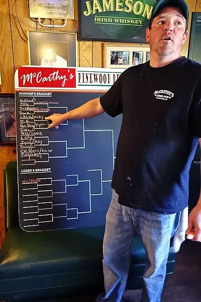 INSTIGATOR!: McCarthy’s bartender and race organizer Patty Kirby fills out the bracket in the double elimination races. - PHOTO BY GLEN STARKEY