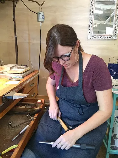 SOLDERING AWAY: Jeweler Kerry Long cuts, solders, and hammers away at her workspace at The Bunker in SLO as she creates one-of-a-kind metal jewelry. - PHOTO COURTESY OF KERRY LONG