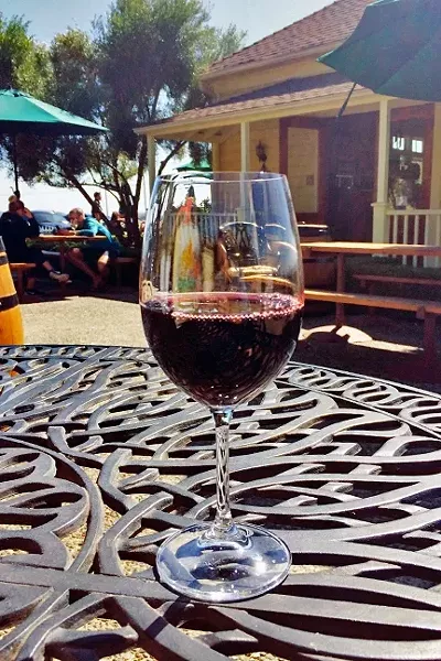 WINE IS FINE: A glass of Baileyana’s Trenza label Obispan red blend goes down easy on a sunny Labor Day weekend. - PHOTO COURTESY OF RYAH COOLEY