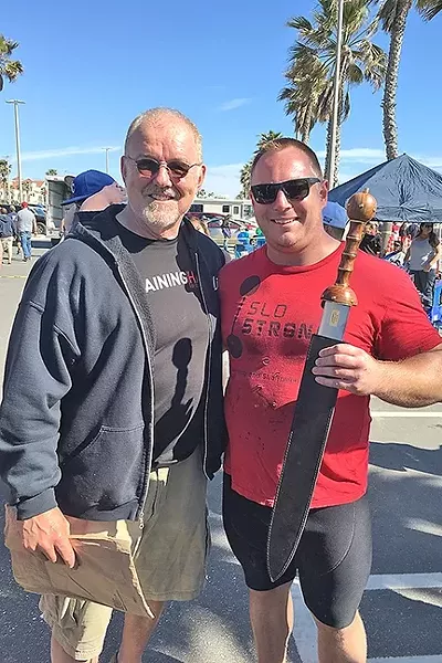 STRONG MAN: Andrew Wickham (right) holds the California’s Strongest Man trophy he won the last weekend in March as he stands next to World’s Strongest Man legend Odd Haugen. - PHOTO COURTESY OF SLO STRONG