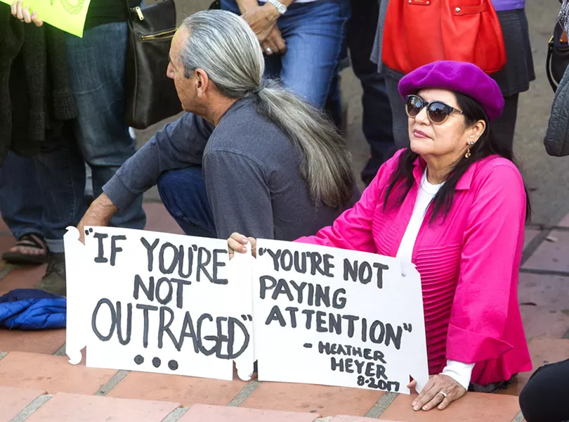 SIGNS OF SUPPORT Many attendees of the Aug. 16 rally in SLO held signs quoting Heather Heyer's final post on social media: "If you're not outraged, you're not paying attention." - PHOTO BY JAYSON MELLOM