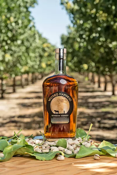 NO REST FOR THE WICKED Farm-to-bottle booze isn't just the stuff of dreams—it's available from Wicked Harvest, owned by Morro Bay residents Jim and Gloria Zion. The couple creates this unique pistachio-infused bourbon whiskey using nuts from their own California Valley fields. The spirit is aged in merlot barrels and distilled in Kentucky. - PHOTO COURTESY OF WICKED HARVEST