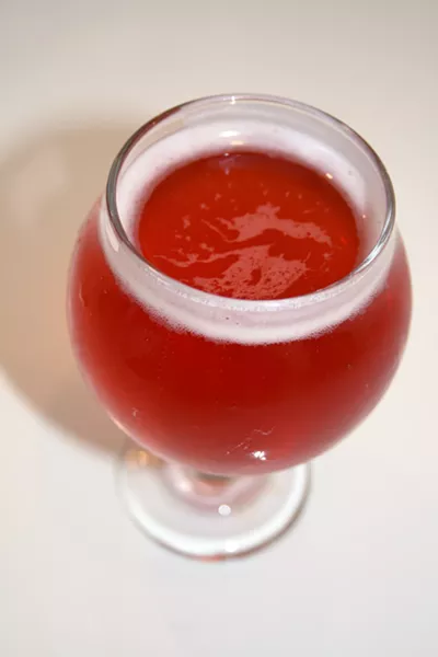RED DELIGHT This fiery looking red pluot cider (left) available at Cider Bar in SLO is just as delicious as it looks. Dozens of ciders from around the world are on tap alongside small plates, craft beer, and boutique wine offerings. - PHOTO BY HAYLEY THOMAS CAIN
