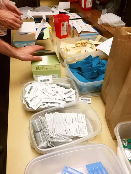 HARM REDUCTION Volunteers at the SLO Bangers Syringe Exchange prepare clean needles and other supplies to give away to drug users in order to help prevent the spread of wounds and diseases. - PHOTO COURTESY OF LOIS PETTY