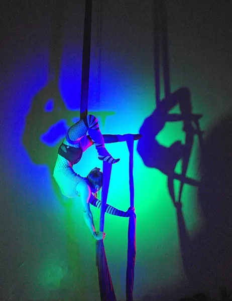 CREEPY CRAWLY Nikki Pesce, an aerialist at Levity Academy, contorts and arches her back while hooking onto the aerial silks. - PHOTO COURTESY OF LEVITY ACADEMY