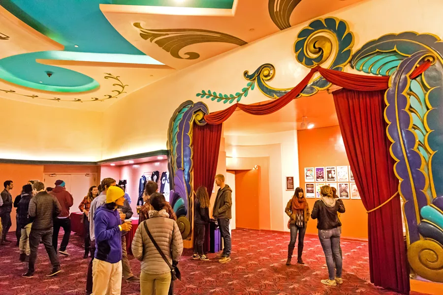 LET'S ALL GO TO THE LOBBY The spacious, colorful lobby has room for artists' merch tables, beer and wine vendors, and its classic snack bar serving up popcorn, candy, sodas, and often Woodstock's pizza. - PHOTOS BY JAYSON MELLOM