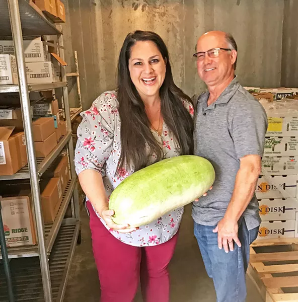 TWO VISIONARIES, ONE MELON FarmSLO founder Jeff Wade (right) stands with Director of Food Services for San Luis Coastal USD Erin Primer as she holds a Charleston Grey melon from a 100-pound box delivered by Robin Song Farms in Templeton. She said she bought them out of their harvest this time around! - PHOTO BY BETH GIUFFRE