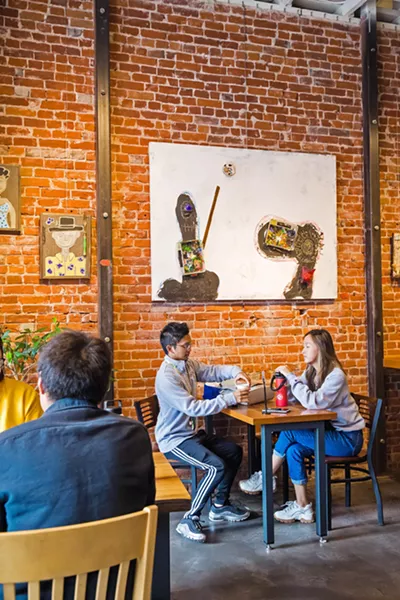 ENHANCING THE EXPERIENCE At Ascendo Coffee, work by artist Vincent Bernardy adds color and character to the cafe's exposed brick walls. - PHOTO BY JAYSON MELLOM