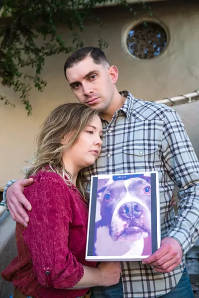 IN MOURNING Nick Regalia and Riley Manford, San Luis Obispo residents, hold up a photo of their dog Bubbers outside their home. A police officer shot and killed it in a fatal encounter in their driveway on Sept. 26, 2019. - PHOTO BY JAYSON MELLOM