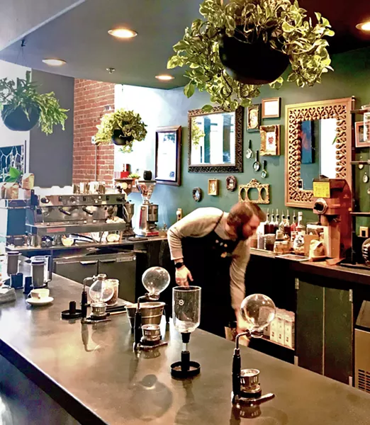 COFFEE LABORATORY Taylor, one of Kin's four baristas, works his magic on his latest order among glass bottles and brew siphons straight from the 1800s. - PHOTO BY BETH GIUFFRE