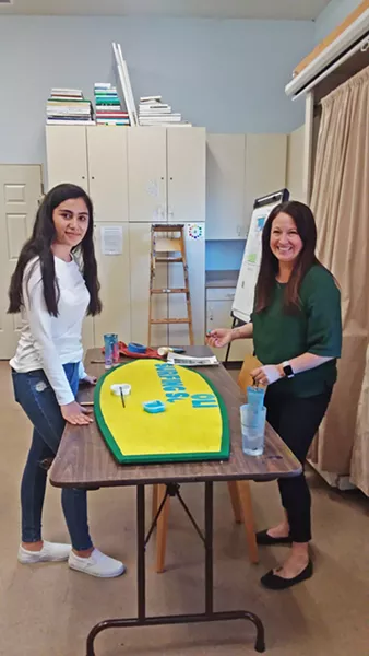 GETTING CREATIVE Student Nathaly, 14, works with Paso Robles Youth Art Foundation Executive Director Mindy Dierks on a surfboard-shaped sign for The Ravine Water Park in Paso Robles. - PHOTO BY REBECCA HOWES