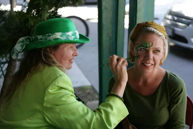 GET YOUR SPIRIT ON: Longtime face painter Teresa Schmidt (481-5093) set up shop in front of McCarthy’s Irish Pub, here painting Laurel White. - PHOTO BY GLEN STARKEY