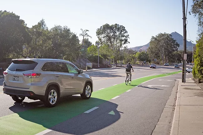 GREEN LANES: SLO hopes to introduce more “protected bike lanes,” such as this stretch on California Boulevard, to separate bikers from high-speed traffic. - PHOTO BY KAORI FUNAHASHI