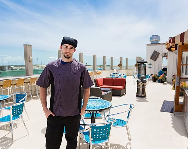 THE ROOF IS ON FIRE : Gaviota Grill Head Chef Jesse Morrow shows off the new restaurant’s crown jewel: a rooftop patio seating area complete with heaters, funky maritime décor, and an unobstructed seaside sunset view. - PHOTO BY KAORI FUNAHASHI