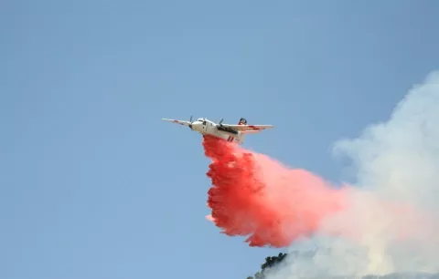 BOMBS AWAY : A CDF bomber dropped a payload of fire retardant - compound on a field of wildfire fuel on June 23. - PHOTO BY JESSE ACOSTA