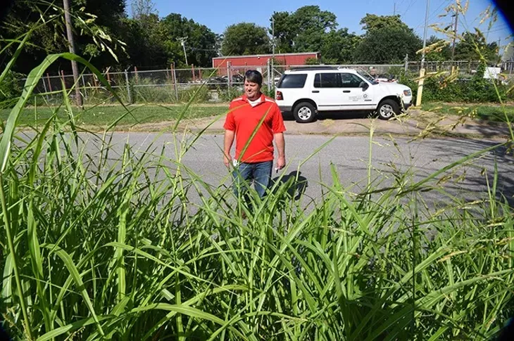David Oen, Chief Building Insperctor for the City of OKC, walks from his truck and surveys the tall Johnson Grass growing in a lot at the corner of S.W. 4 Street & Lee Avenue recently. mh