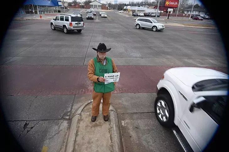 Gary "Cowboy" Fields, a Curbside Chronicle vendor, on the median at Broadway Avenue and N.W. 23rd Street, the last day before city ordinance prohibiting panhandling from medians like this, takes effect, 1-6-16. - MARK HANCOCK