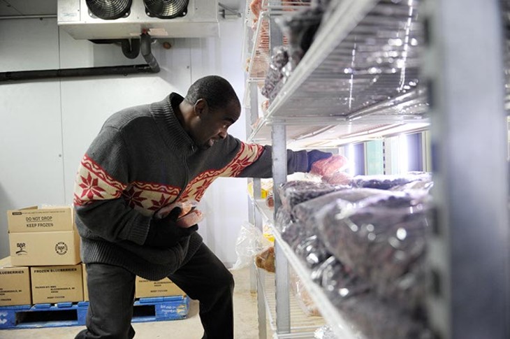 Mike Fulsom, a volunteer, stockes a freezer at Skyline Urban Ministry in Oklahoma City, Monday, Nov. 24, 2014. - GARETT FISBECK