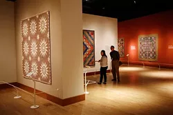 Seth Spillman and Tabbi Burwell look at quilts during the Quilts and Color Media tour, Wednesday, November 4, 2015. - GARETT FISBECK