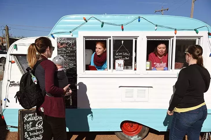 Customers Molly, left, and Samantha Cooper, order some hot chocolate at the Katiebut's camper, from Autumn Urton, left, and Jen Bellah, at the Holiday Pop-Up Shops in Midtown, 12-18-15, Oklahoma City. - MARK HANCOCK