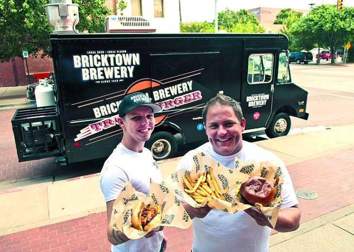 Left, Ryan Reynolds and Blake Lippert with hotdogs, fries and Burgers, surved by the Truckburger truck, parked behind them in Bricktown. (Mark Hancock)