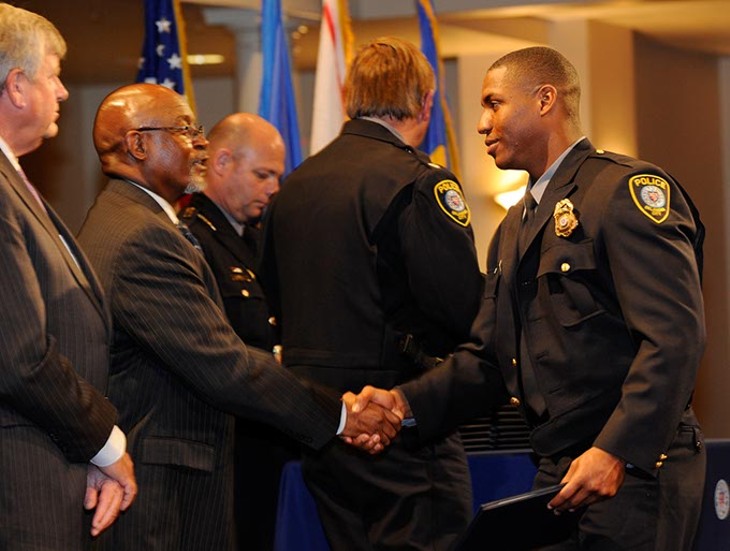 Anthony Anderson, right, graduates during the Oklahoma City Police Academy Recruit Class 132 graduation at First United Methodist Church, Thursday, Dec. 4, 2014. - GARETT FISBECK