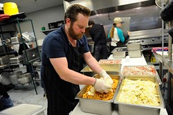 Russ Johnson helps  preps lunch at WestTown day shelter in Oklahoma City, Tuesday, March 24, 2014. - GARETT FISBECK