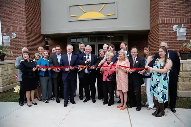 Dignitaries cut a ribbon during a grand opening ceremony at Sunbeam Family Services in Oklahoma City, Thursday, May 7, 2015. - GARETT FISBECK
