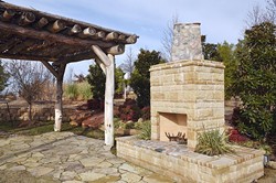 A rustic pergola next to an outdoor fireplace, part of the lanscaping on the grounds of Tony's Tree Plantation which will be exhibiting at this year's Oklahoma City Home and Garden Show.  mh