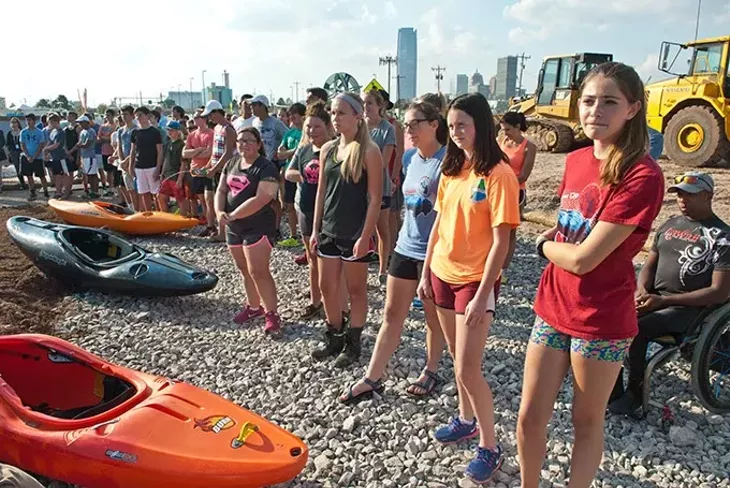 Young athletes watch the proceedings next of kayaks during the groundbreaking ceremonies for the newly named River Sport Rapids along the Oklahoma River in the Boathouse districe, Monday, 10-20-2014. mh