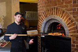 Dylan Lynch makes a pizza in Tommy's wood fire oven. (Shannon Cornman)