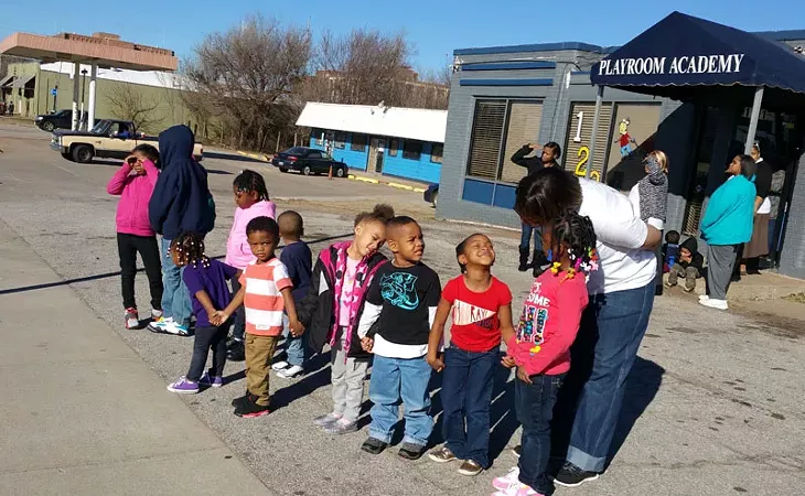 Angela Billings brings a class from Playground Academy daycare out to 23rd Street to watch a march on Martin Luther King Jr. Day. - BEN FELDER