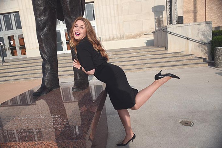 Allison Goodman, a member of Overture young professionals group, plays around at the base of the conductor sculpture in front of the Civic Center Music Hall.  mh