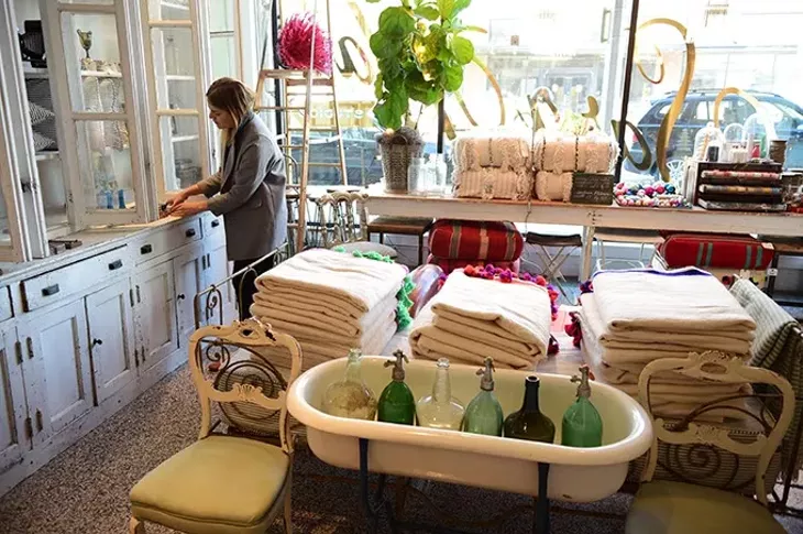 Sara Kate Huff, owner of Sara Kate Studios in Automobile Alley, works with her inventory at the new shop. mh