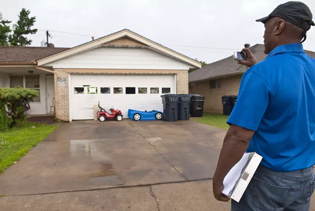 Ron Pollard, municipal code officer I, for the City of OKC, takes a photo after arriving at a vacant property at 1324 SW 43rd during an inspection, 6-19-14. mh
