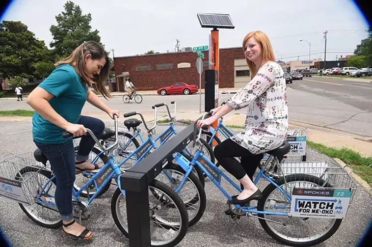 From left, Amanda Laija and Ashleigh Arnall try out the new Sokies bikes at the station in the Elemental Coffee parking lot at NW 8th and Hudson Avenue. mh