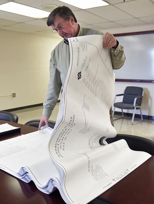 Cody Thompson, executive director of facilities, looks over the blueprints for the recent improvements at Rogers Middle School.  mh