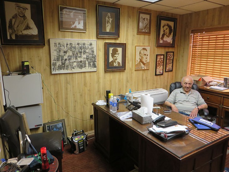Lindy Shanbour sits in his busy office amid prized movie posters that he has collected during his long career in the movie business. - BRETT DICKERSON