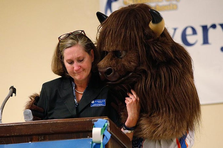 Rumble hugs Principal Nikki Coshow as she becomes emotional during a ceremony at Bodine Elementary School in Oklahoma City, Monday, May 11, 2015. - GARETT FISBECK